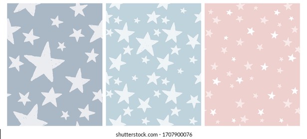 3 Varius Star Vector Patterns. Irregular Hand Drawn Starry Sky Print. Grunge Space Backdrop. Infantile Freehand Drawing. Irregular Star Print on a Light Blue, Graphite and Pastel Pink Background. 