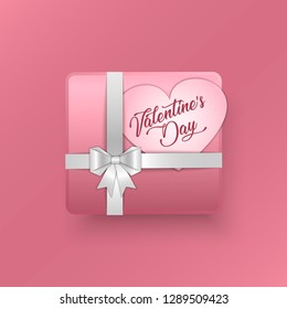 3d gift box with paper bow and ribbon on pink background. On box cut out paper heart with a happy Valentine's day greetings. Design concept for Valentine's Day. Vector illustration.