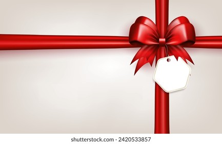 3d red bow with horizontal and vertical silk ribbons and paper label tag on white background with copy space. Scarlet bow with crossed tapes as gift box wrap or greeting card with empty place for text