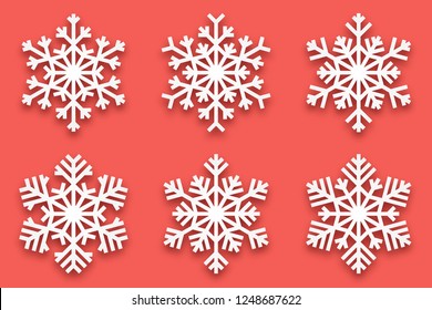 3D Vector Papercut Decorative Handmade Snowflakes Set with Soft Drop Shadow Isolated on Light Red Background. Merry Christmas and Happy New Year Decoration Design Element