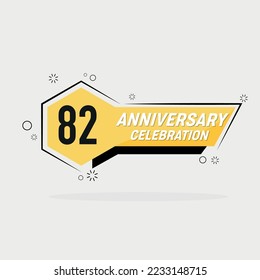 Logo del 82º aniversario, diseño vectorial con forma geométrica amarilla con fondo gris.