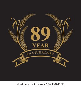 89 golden anniversary logo with ring and ribbon, laurel wreath vector design isolated on black background