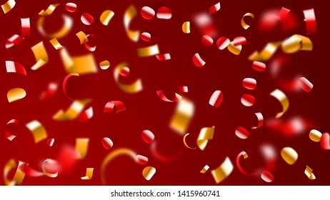 Abstract background of flying shiny confetti and pieces of serpentine, golden and yellow on red