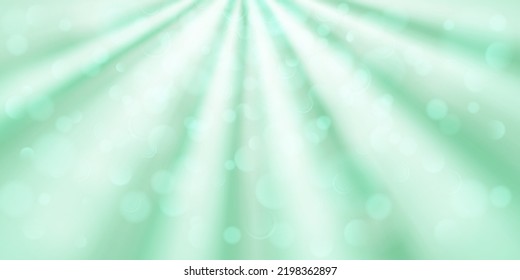 Abstract background in light green colors with diverging rays of light and small translucent circles with bokeh effect