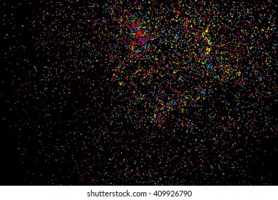 Abstract black background with falling confetti. Many round random tiny glitter pieces.