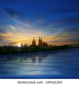 abstract blue background with sunrise and silhouette of cologne