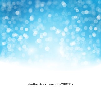 Abstract blue white background with blurry lights that give it a magical feeling as a backdrop for the Christmas season or any festive occasion.