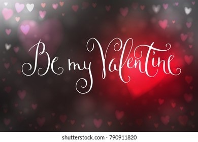 Abstract blur gray and red background with heart-shaped lights over it and hand written Valentine's day greetings.