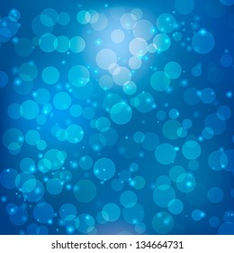 Abstract bokeh background with particles on dark blue background.
