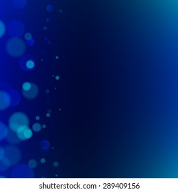 Abstract bokeh sparkles on dark blue blurred background
