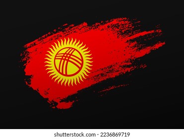 Resumen creativo patriótico con la mano pintada con la bandera de Kirguistán en un fondo negro