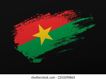 Resumen creativo patriótico con la mano pintada con la bandera de Burkina Faso sobre fondo negro