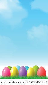 Abstract Easter bokeh background with colorful eggs lying on the grass against the sky background