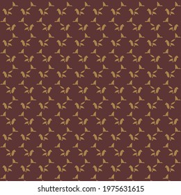 Abstract elements, small golden petals in an arrangement on a burgundy red background. Fashion pattern.