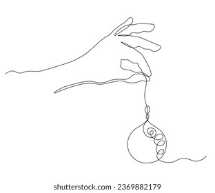abstract hand with a Christmas toy decorates the Christmas tree, preparations for Christmas. Continuous one line art