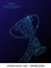 Abstract image of a champion cup in hand in the form of a starry sky or space, consisting of points, lines, and shapes in the form of planets, stars and the universe.