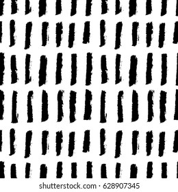 Abstract monochrome seamless pattern with ink black vertical hand drawn brushes. Grunge lines, or stripes isolated on white background. Minimalistic naive scandinavian design. Vector illustration.