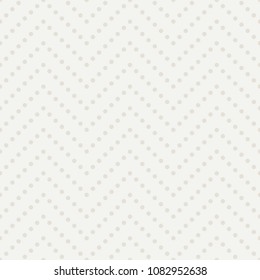 Abstract polka dot background. Light seamless vector pattern. Diagonal zigzag arrangement of elements. Gray retro wallpaper with small circles. Repeating decorative textile texture.