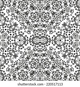 Abstract seamless background with black symbolical floral patterns on white. Vector