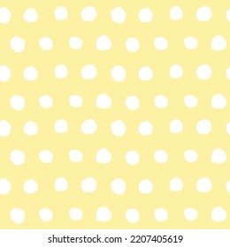 Abstract seamless background with hand drawn polka dots, gentle childish yellow and white pattern, minimalist design