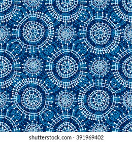 Abstract seamless geometric pattern in doodle style. White snowflakes and small circles on blue background, hand drawn. For background design and decoration, wallpaper, packaging, fabrics, textiles.