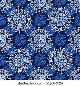 Abstract seamless geometric pattern in doodle style. White snowflakes on blue background, hand drawn. 