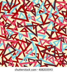 Abstract seamless pattern of pink, maroon and blue overlapping triangles chaotic scattered on a light yellow background.