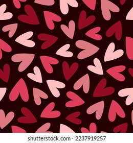 Abstract seamless pattern with red, pink and purple hearts on dark background. Hand drawn doodle style. Vector illustration