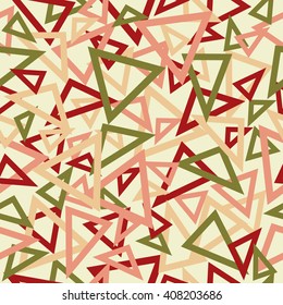 Abstract seamless pattern of red, pink and green overlapping triangles chaotic scattered on a light yellow background.