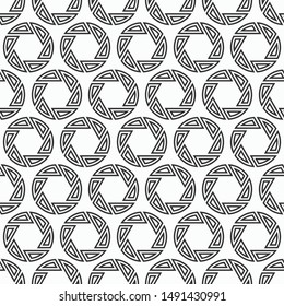 Abstract seamless pattern of repeating round striped circular ornaments isolated on white background. Camera lens aperture icons. Vector monochrome illustration.