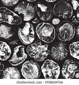 Abstract seamless pattern with saw cut tree trunks isolated on black backdrop. Wooden texture with rings and cross sections of old trees. Black and white vector background with various shaped stumps