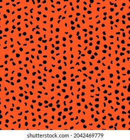Abstract seamless pattern from small shapes. Simple background of irregular spots. Abstract wild animal skin print. Random spaced black spots. Vector illustration on deep orange background