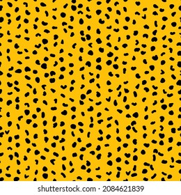 Abstract seamless pattern from small shapes. Simple background of irregular spots. Abstract wild animal skin print. Random spaced black spots. Vector illustration on amber background
