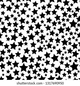 Abstract seamless pattern of stars of different sizes in black and white colors