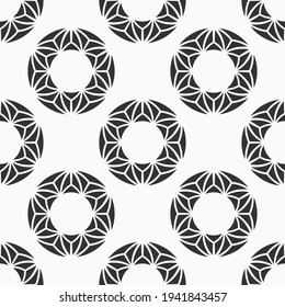 Abstract seamless pattern with symmetric circle shapes, made of triangles. Repeating geometric ornament. Modern stylish texture. Vector monochrome background.