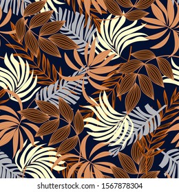 Abstract seamless tropical pattern with bright beige plants and leaves on a blue background. Vector design. Jungle print. Floral background.  Tropical botanical.