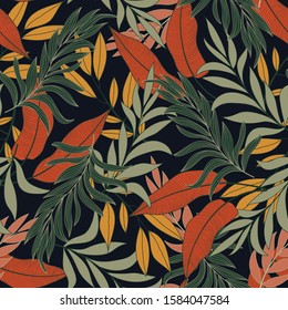 Abstract seamless tropical pattern with bright yellow and red plants and leaves on a black background. Beautiful seamless vector floral pattern. Tropic leaves in bright colors.