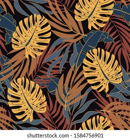 Abstract seamless tropical pattern with bright yellow plants and leaves on a dark background. Vector design. Jungle print. Floral background.  Exotic jungle wallpaper.