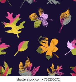 Abstract seamless vector pattern of colorful autumn leaves carried by the wind. Pink, green and yellow brush strokes inside of shapes on a dark blue background.