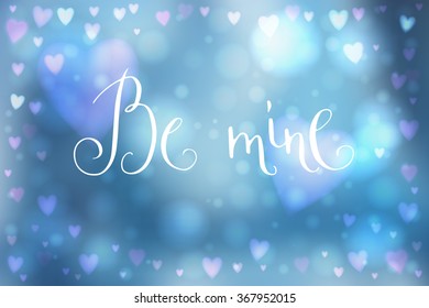 Abstract smooth blur blue background with heart-shaped lights over it and hand written Valentine's day words.