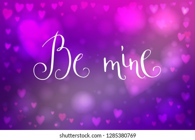 Abstract smooth blur purple background with heart-shaped lights over it and hand written Valentine's day words.