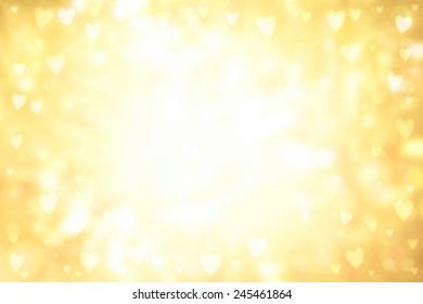 Abstract smooth blur yellow background with small heart-shaped lights over it.