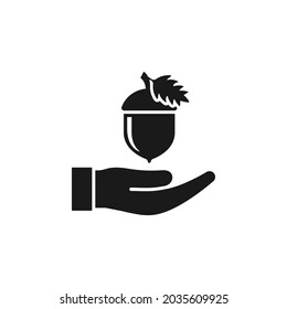 Acorn on hand icon flat style isolated on white background. Vector illustration