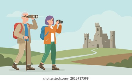 Active senior couple hikes through the countryside and explores a historic castle ruin with binoculars and a camera.