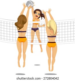 Active woman jumping doing smash attack while two athletic volleyball players are blocking ball