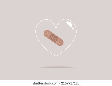 An Adhesive Plaster Sticked To A Transparent Glass Heart, A Heartbreak Concept