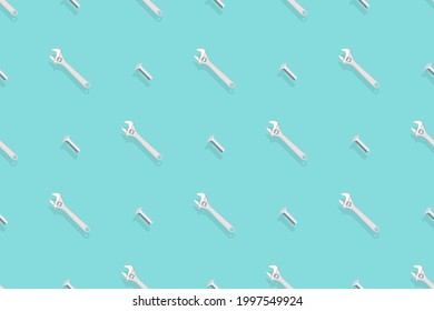 Adjustable metal wrench seamless pattern. Background from a metal wrench and a bolt. 