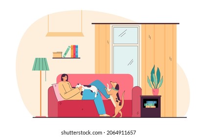 Adorable smiling young girl lying on cozy sofa with dog and cat. Portrait of happy pet owner on couch at home flat cartoon vector illustration. Relax, hygge, love of animal concept