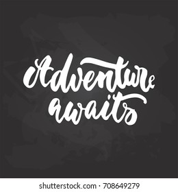 Adventure awaits - travel hand drawn lettering quote in white color on the black chalkboard background. Fun ink calligraphy inscription