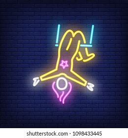 Aerial acrobat neon sign. Female circus gymnast on trapeze on dark brick wall background. Night bright advertisement. Vector illustration in neon style for performance poster or festival